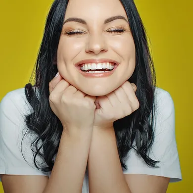 Lächelnde Junge Frau sagt "Cheeese"